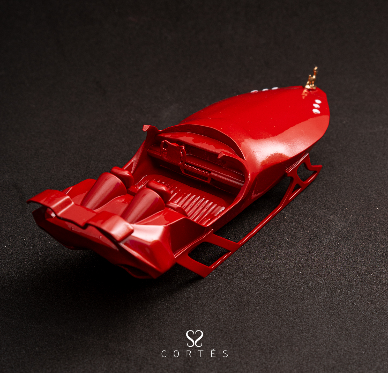 Modelo de trineo rojo sobre una superficie negra.